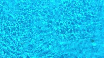 Blue water in the swimming pool with light reflections.