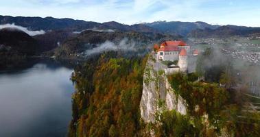 aéreo ver de blejski graduado, castillo construido en parte superior de un roca. Eslovenia. video