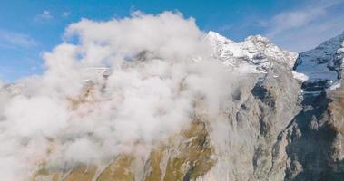 aéreo ver de el rocoso picos de suizo Alpes con nubes video