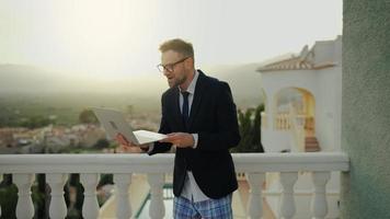 Man in a jacket and underwear negotiates at home on the terrace of a villa video