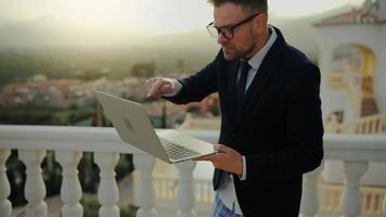 Man in a jacket and underwear negotiates at home on the terrace of a villa video