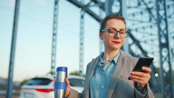 vrouw in een jas, wandelen in de omgeving van de stad in de vroeg ochtend, drinken koffie video