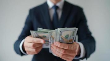 Formally dressed man counting US Dollar bills, close-up. video