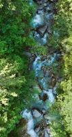 Vertikale Video. oben Nieder Aussicht ein Berg Fluss fließend unter groß Steine video