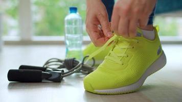 Woman tying shoelaces on sneakers going for training or jogging video