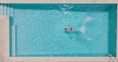 Aerial view as a man dives into the pool and swims video