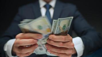 Formally dressed man counting US Dollar bills, close-up. video