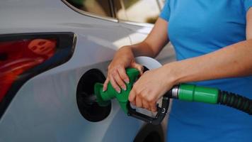 mujer inserta un combustible pistola en un gas tanque a repostar un coche video