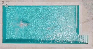 aéreo ver como un hombre inmersiones dentro el piscina y nada video