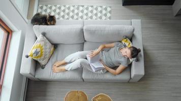 Overhead Aussicht von Frau lesen das Buch, Lügen auf Couch beim Zuhause video