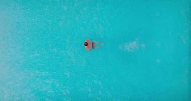 aéreo ver como un hombre inmersiones dentro el piscina y nada video