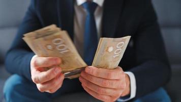 formeel gekleed Mens tellen Canadees dollar rekeningen, detailopname. video