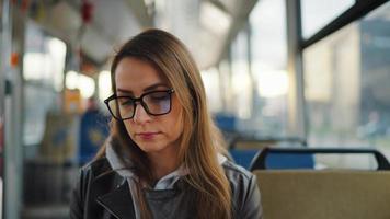 público transporte. mujer en lentes montando un tranvía en el ciudad video