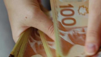 vrouw handen tellen Canadees dollar rekeningen, detailopname. video