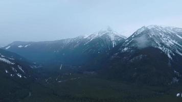 aéreo ver de invierno rocoso montañas durante el nevada. chiliwack video