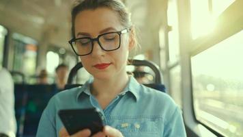 openbaar vervoer. vrouw in bril in tram gebruik makend van smartphone video