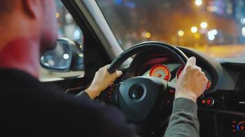 Mann Fahren Auto durch das Straßen von Nacht Stadt. video