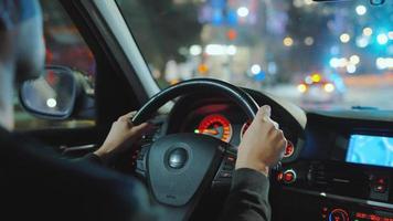uomo guida auto attraverso il strade di notte città. video
