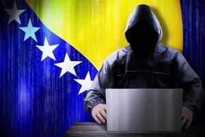 anónimo encapuchado hacker y bandera de bosnia y herzegovina binario código - ciber ataque concepto foto