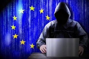 Anonymous Hooded Hacker and Flag Of European Union, Binary Code - Cyber Attack Concept photo