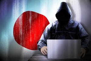Anonymous Hooded Hacker and Flag Of Japan, Binary Code - Cyber Attack Concept photo