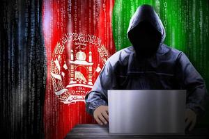 Anonymous Hooded Hacker and Flag Of Afghanistan, Binary Code - Cyber Attack Concept photo