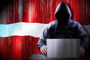 Anonymous Hooded Hacker and Flag Of Latvia, Binary Code - Cyber Attack Concept photo