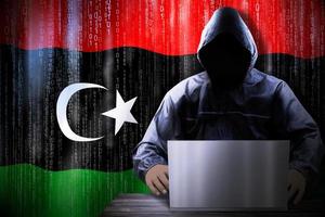 anónimo encapuchado hacker y bandera de Libia, binario código - ciber ataque concepto foto