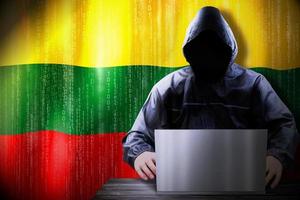 Anonymous Hooded Hacker and Flag Of Lithuania, Binary Code - Cyber Attack Concept photo