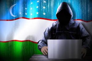Anonymous Hooded Hacker and Flag Of Uzbekistan, Binary Code - Cyber Attack Concept photo