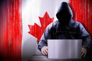 Anonymous Hooded Hacker and Flag Of Canada, Binary Code - Cyber Attack Concept photo