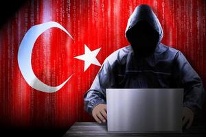 Anonymous Hooded Hacker and Flag Of Turkey, Binary Code - Cyber Attack Concept photo