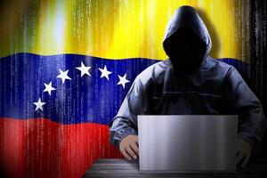 Anonymous Hooded Hacker and Flag Of Venezuela, Binary Code - Cyber Attack Concept photo