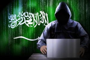 Anonymous Hooded Hacker and Flag Of Saudi Arabia, Binary Code - Cyber Attack Concept photo