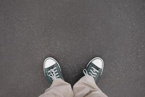 piernas con entrenador Zapatos en pie en asfalto - piernas con entrenador Zapatos foto