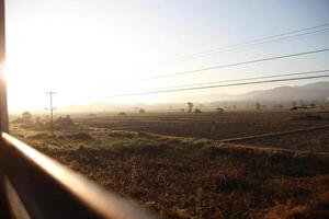 farm with sun ray window view from train photo