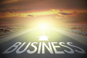 Business word on a road and sunset sky photo