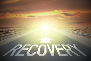 Recovery word on a road and sunset sky photo