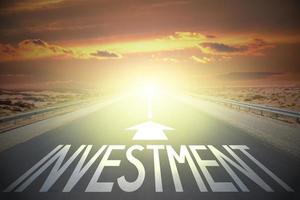 Investment word on a road and sunset sky photo