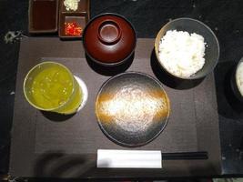 japonés comida conjunto con miso sopa , verde té y arroz con palillo foto