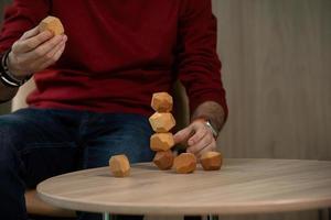 Male hands put together different figures from wooden polyhedrons, eco games for adults and children, antistress toys made of natural wood photo