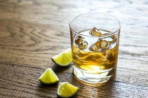 Glass of rum on the wooden background photo