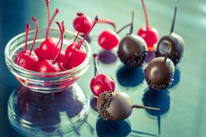 Chocolate and cocktail cherries on the glass photo