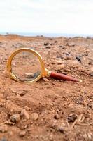 Magnifying glass in the sand photo