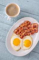 Fried eggs with bacon photo