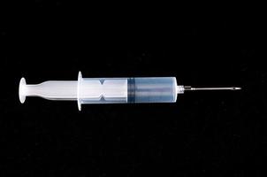 Syringe on dark background photo