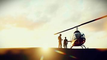 Silhouette zwei Geschäftsmann warten zum Hubschrauber erhalten bereit zum fliegend im das Abend, 3 Wiedergabe. video