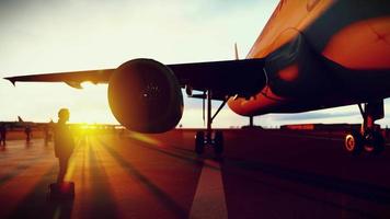 silueta hombre con bolso en pie debajo avión ala en avión estacionamiento lugar, empresario obtener Listo para viaje en aeropuerto a puesta de sol tiempo, 3d representación. video
