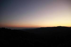 sunrise sunset sky with clouds over the mountain view background photo