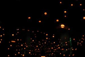 blur bokeh circus tube lamp hang from ceiling in black dark room like firefly photo